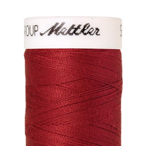 Könnte beinhalten: Eine Spule roten Fadens mit dem Text "GROUP Mettler" auf dem Etikett.