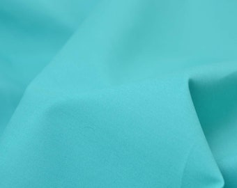 Op de afbeelding: Close-up van een gladde, turquoise stof met een subtiele textuur. De stof is gevouwen en gedrapeerd, waardoor zachte bochten en plooien ontstaan.