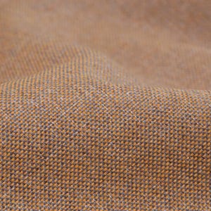 Puede incluir: Primer plano de una tela tejida marrón con una textura sutil. La tela tiene un tacto ligeramente rugoso y un tono natural y terroso.