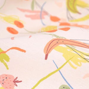 May include: A white fabric with a colorful abstract pattern. The pattern includes orange, yellow, green, and pink lines and shapes. There are also images of a banana and a strawberry.