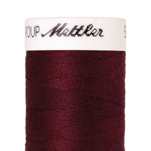 May include: A spool of maroon thread with the text "GROUP Mettler" on the label.