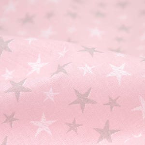 Può includere: Tessuto rosa con un motivo a stelle bianche e grigie ripetuto.