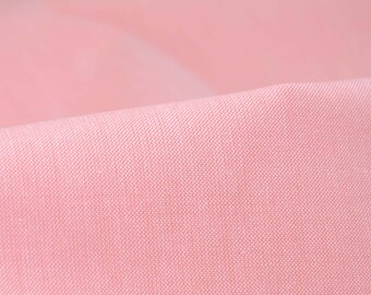 Puede incluir: Primer plano de una tela rosa pálido con una textura tejida sutil.