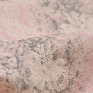 Pode incluir: Close-up de um tecido floral rosa e cinza com uma trama de linho texturizada. O tecido apresenta um padrão repetitivo de flores e folhas estilizadas.
