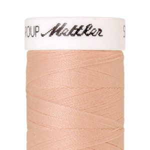 Puede incluir: Una bobina de hilo de color melocotón pálido con el texto "Metzler" en la etiqueta.