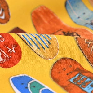 May include: Yellow fabric with a repeating pattern of colorful shoes. The shoes are all different styles and have various designs, including stripes, waves, and text.