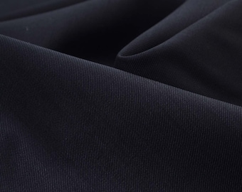 Könnte beinhalten: Nahaufnahme eines dunkelblauen Stoffes mit einer subtilen Rippenstruktur. Der Stoff ist glatt und wirkt weich.