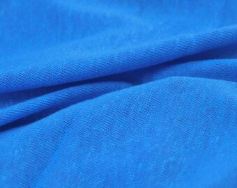 May include: Close-up of a blue fabric with a textured surface. The fabric is folded and has a soft, smooth feel.
