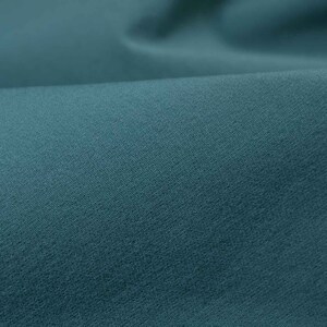 May include: A close-up of a smooth, teal fabric with a subtle texture. The fabric is soft and has a slightly sheen finish.