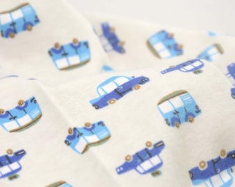 Puede incluir: Una tela blanca con un patrón repetido de coches y furgonetas azules. Los coches y las furgonetas están todos orientados en la misma dirección y tienen un diseño simple y de dibujos animados.