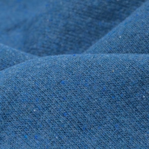 Könnte beinhalten: Nahaufnahme eines blauen Stoffes mit einer strukturierten Oberfläche. Der Stoff hat eine leicht raue Haptik und ein dezentes, gesprenkeltes Muster.