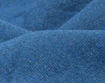 Pode incluir: Close-up de um tecido azul com uma superfície texturizada. O tecido tem um toque ligeiramente áspero e um padrão sutilmente salpicado.