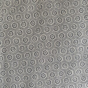 Puede incluir: Tela blanca con un patrón repetitivo de pequeños círculos negros dispuestos en forma circular.