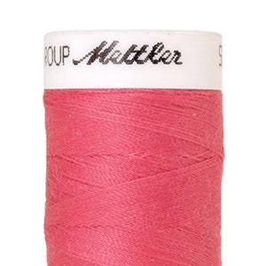 Peut inclure: Une bobine de fil rose avec le texte "GROUP Mettler" sur l'étiquette.
