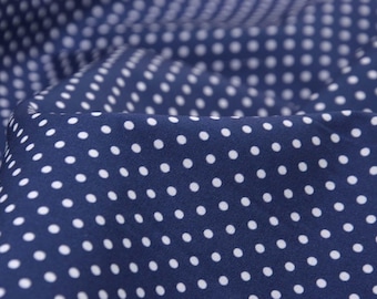 May include: Close-up of navy blue fabric with a repeating pattern of white polka dots. The fabric is gathered, creating soft folds and shadows. The polka dots are evenly spaced and add a classic touch to the textile.