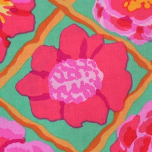 Op de afbeelding: Close-up van een stof met een bloemenpatroon. Grote roze en rode bloemen met lichtroze centra staan tegen een lichtgroene achtergrond. De bloemen worden omlijst door een oranje traliewerk.