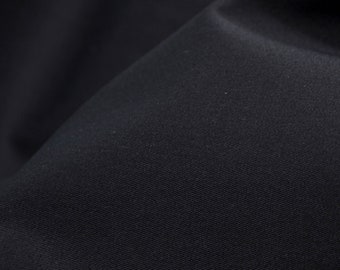 Peut inclure: Gros plan sur un tissu bleu foncé avec une texture subtile. Le tissu a une surface lisse et uniforme et une finition légèrement brillante.