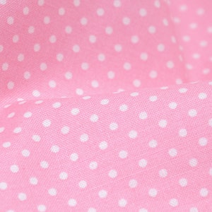 Può includere: Tessuto rosa con un motivo a pois bianchi. Il tessuto è testurizzato e ha una leggera lucentezza.