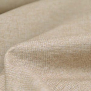 May include: Close-up of a beige fabric with a subtle woven texture. The fabric has a soft, natural look and feel.
