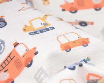 Puede incluir: Tela blanca con un patrón repetido de varios vehículos en naranja, amarillo y azul. Los vehículos incluyen un camión de bomberos, un vehículo de construcción, un automóvil y una camioneta.