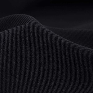 May include: Close-up of a black fabric with a textured weave. The fabric has a subtle sheen and a smooth, soft feel.