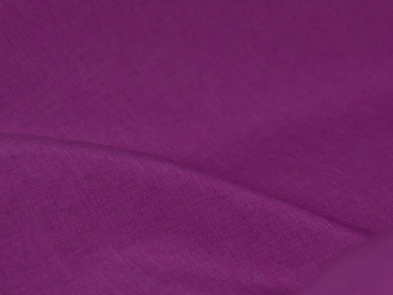 May include: A close-up of a deep purple fabric with a smooth, textured surface.