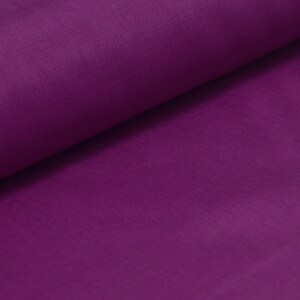 May include: A close-up of a smooth, deep purple fabric. The fabric is folded in half, creating a soft, gentle curve.