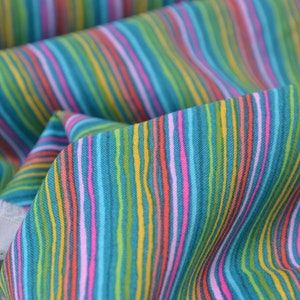 Puede incluir: Tela turquesa con rayas de colores en rosa, amarillo, naranja y verde.