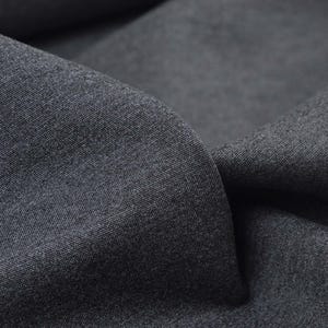 May include: Close-up of a dark grey fabric with a textured surface.