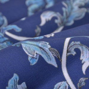 May include: Blue fabric with a white floral pattern. The fabric has a subtle texture and a soft, flowing drape.
