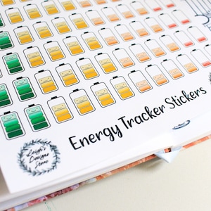 Könnte beinhalten: Ein Blatt mit Energiespuren-Aufklebern mit verschiedenen Batterie-Symbolen in verschiedenen Farben, darunter Grün, Gelb und Orange. Die Aufkleber sollen Menschen helfen, ihre Energieniveaus im Laufe des Tages zu verfolgen. Das Blatt enthält auch den Text "Energy Tracker Stickers".