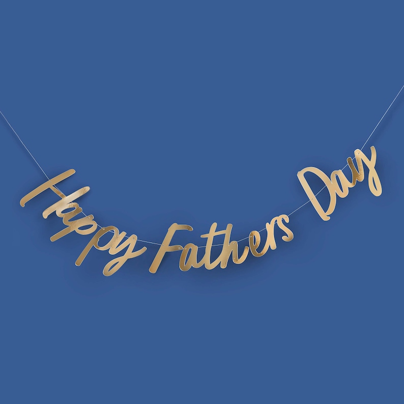 May include: Gold Happy Fathers Day banner with cursive lettering on a blue background.