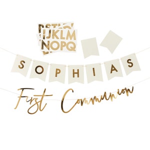 May include: Gold foil banner with the words "Sophia's First Communion" on a white background. The banner is strung together with white flags and gold letters.
