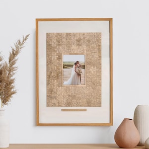 Peut inclure: Cadre en bois clair contenant une photo de mariage. La photo est entourée d'un motif en forme de pièces de puzzle avec des notes manuscrites. Une petite plaque en bas indique "THE BEST DAY EVER WAS YESTERDAY".