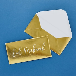 May include: Two gold envelopes, one with a white interior and the other with the text "Eid Mubarak" in white lettering.