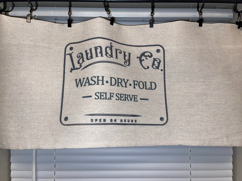 May include: A white canvas valance with black text that reads "Laundry Co. WASH. DRY. FOLD - SELF SERVE - OPEN 24 HOURS".