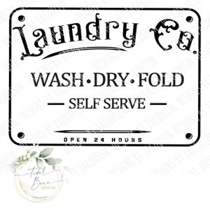 Op de afbeelding: Zwart-wit bord "Laundry Co." met de woorden "WASH DRY FOLD SELF SERVE" en "OPEN 24 HOURS". Het bord heeft een rechthoekige vorm met afgeronde hoeken en decoratieve klinknagels.