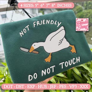 Op de afbeelding: Een donkergroene sweatshirt met de geborduurde tekst "NOT FRIENDLY DO NOT TOUCH". Het ontwerp toont een witte gans met een mes. De tekst "4 MATEN: 12.7cm 15.2cm 17.8cm 20.3cm" staat bovenaan.