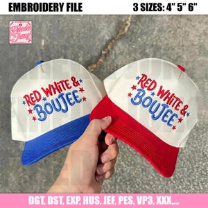 Könnte beinhalten: Zwei weiße Trucker-Caps mit roten und blauen Akzenten. Jede Cap hat den gestickten Text "RED WHITE & BOUJEE" in Rot und Blau, mit Sternen. Erhältlich in den Größen 10,16 cm, 12,7 cm und 15,24 cm.