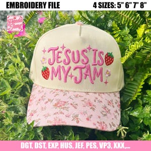 Könnte beinhalten: Cremefarbene Baseballkappe mit pinkfarbenem, floral gemustertem Schirm. Die Kappe zeigt den gestickten Schriftzug "JESUS IS MY JAM" in Pink, zusammen mit Erdbeer- und Blumendesigns. Erhältlich in 4 Größen: 12.7cm, 15.2cm, 17.8cm und 20.3cm.