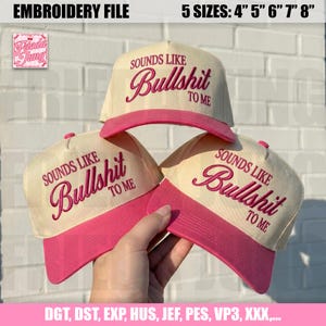 May include: Three cream-colored baseball caps with pink brims, each featuring the embroidered text 'SOUNDS LIKE Bullshit TO ME' in pink. The image includes text indicating an embroidery file available in 5 sizes from 4 inches to 8 inches.