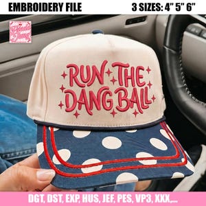 Könnte beinhalten: Eine cremefarbene Baseballkappe mit dunkelblauem Schirm, weißen Punkten und zwei roten Ziernähten. Auf der Vorderseite befindet sich der rote Stickschriftzug RUN THE DANG BALL, umgeben von kleinen roten Sternen. Enthält 4, 5, 6 Zoll Größen.