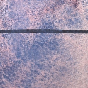 May include: A close-up of a textured surface with a horizontal black line across the middle. The surface is a mix of light blue and pink.
