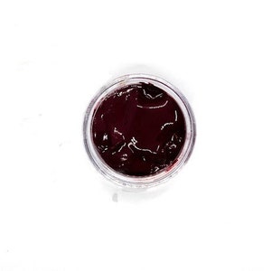 May include: A small, clear jar filled with a dark red, almost black, substance. The substance has a smooth, glossy surface.