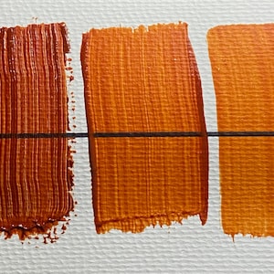 Pode incluir: Três amostras de tinta em uma superfície branca. As amostras são todas em tons de laranja, sendo a amostra mais à esquerda a mais escura e a amostra mais à direita a mais clara.