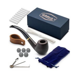 Puede incluir: Una pipa de fumar de madera oscura con una boquilla negra y una banda dorada. La pipa viene con una bolsa de terciopelo azul, una herramienta de limpieza, un paquete de filtros para pipa y un paquete de pantallas para pipa. La pipa está empaquetada en una caja azul con el texto "Whittock's" en la parte superior.