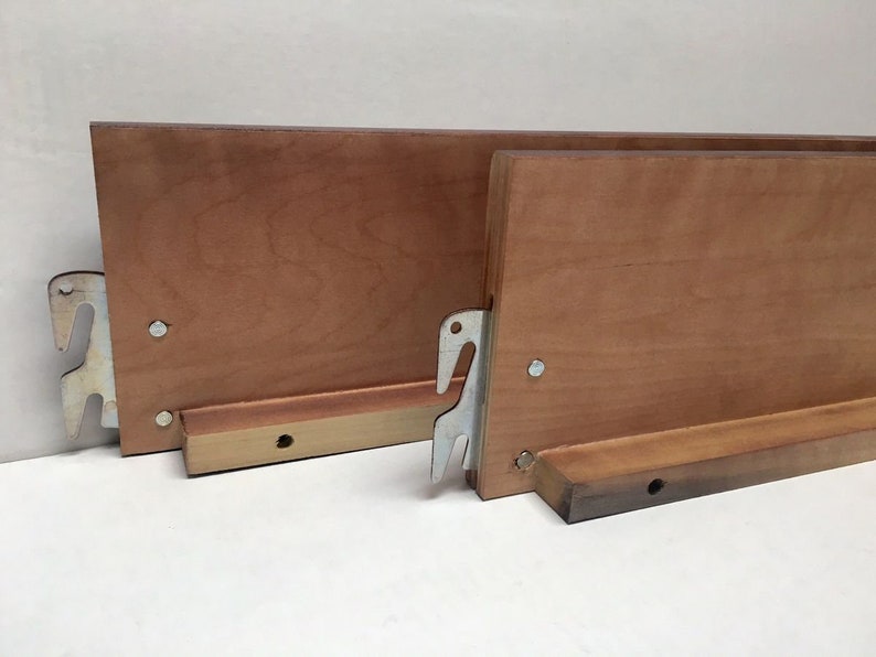 May include: Two wooden bed slats with metal brackets. The slats are light brown and have a smooth finish. The brackets are silver and have a simple design.
