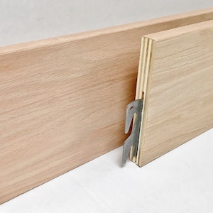 May include: Two wooden bed slats with metal brackets. The slats are made of light wood and have a natural finish. The brackets are silver and are attached to the underside of the slats.