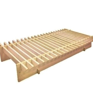 Könnte beinhalten: Ein Lattenrost aus Holz mit einer Lattenplattform und einem leicht abgewinkelten Design. Der Rahmen ist aus Naturholz gefertigt und hat eine hellbraune Oberfläche.