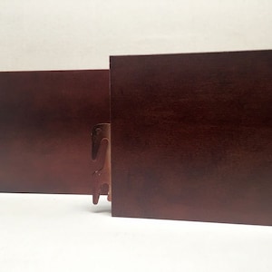 May include: Two brown wooden bed headboard brackets with metal clips. The brackets are designed to attach to a bed frame.